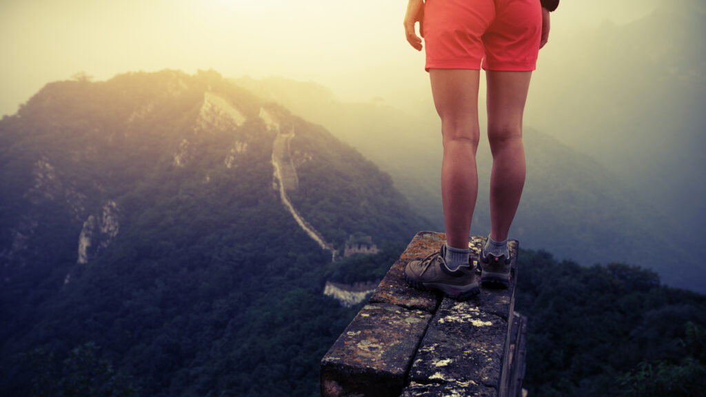 person standing on mountain precipice