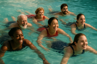 men and women swimming in the blue-green water with smiles on their faces
